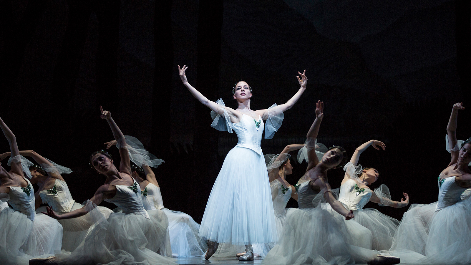 Woman in a white tutu, surrounded by other women