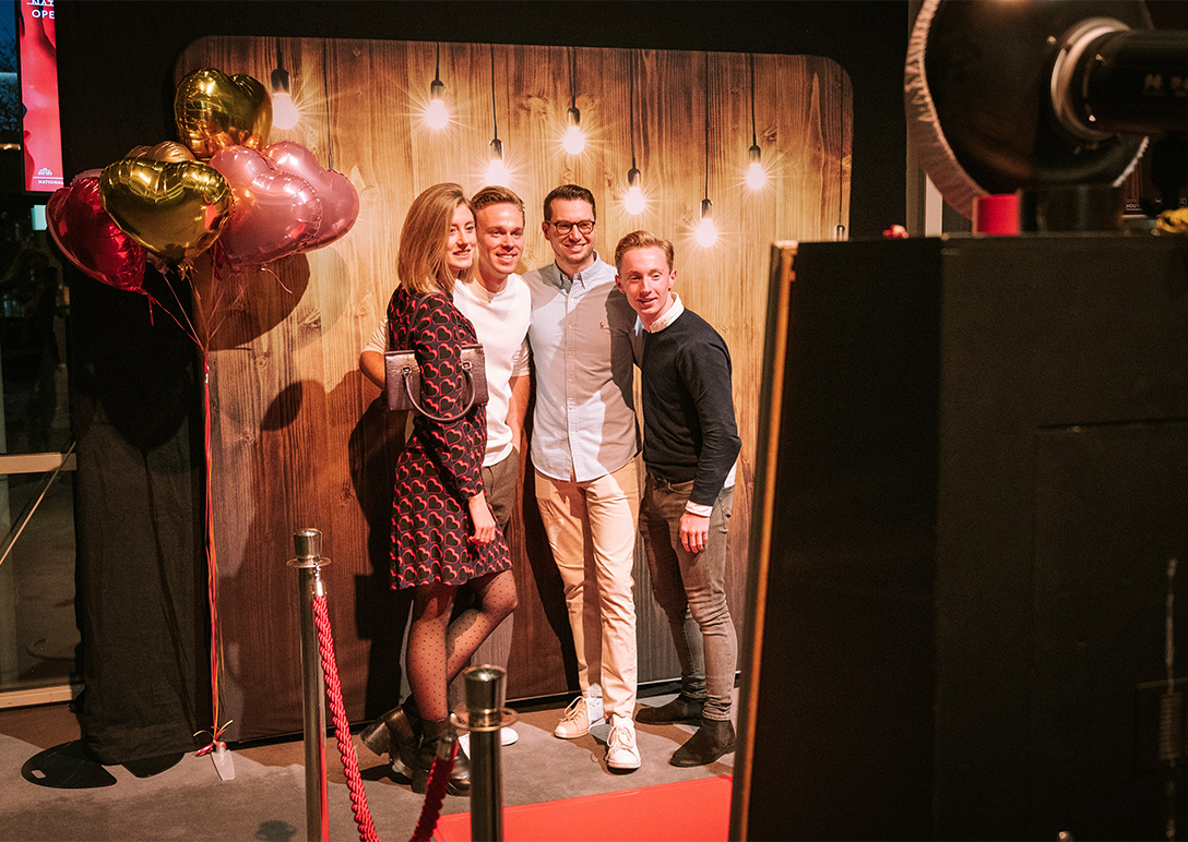 Vier personen staan in de photobooth in de foyer