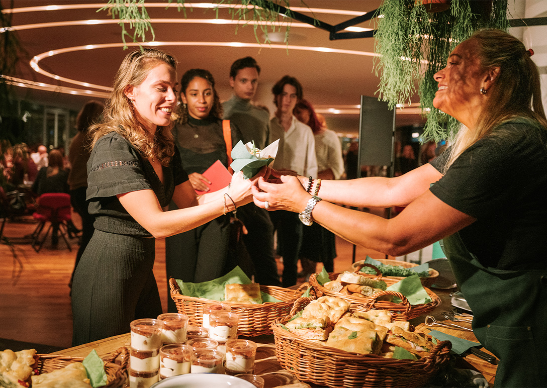 Vrouw krijgt eten van de foodstand in de foyer